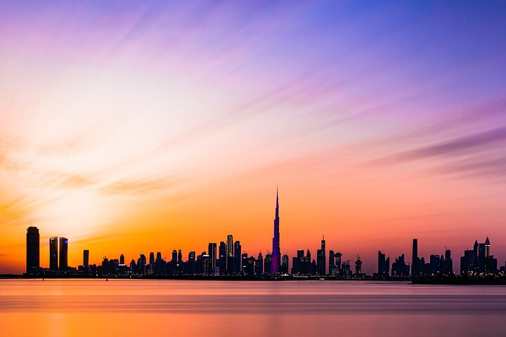 Experience Dubai's iconic skyline at sunset where towering skyscrapers meet the serene waters inviting travelers to explore the rich culture and stunning landscapes of this dynamic city.